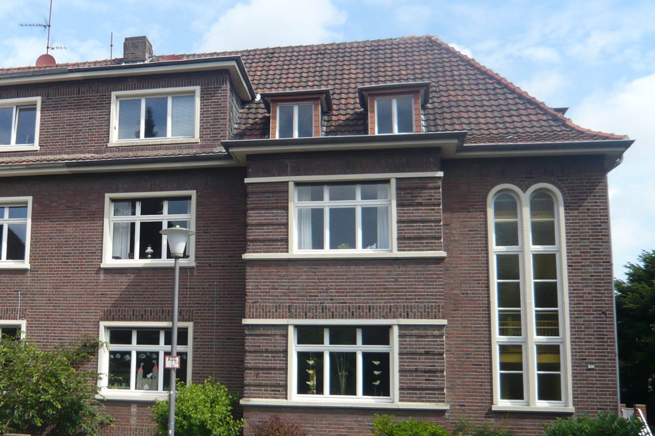 Denkmalgeschütztes Backsteinhaus mit hohem Rundbogenfenster