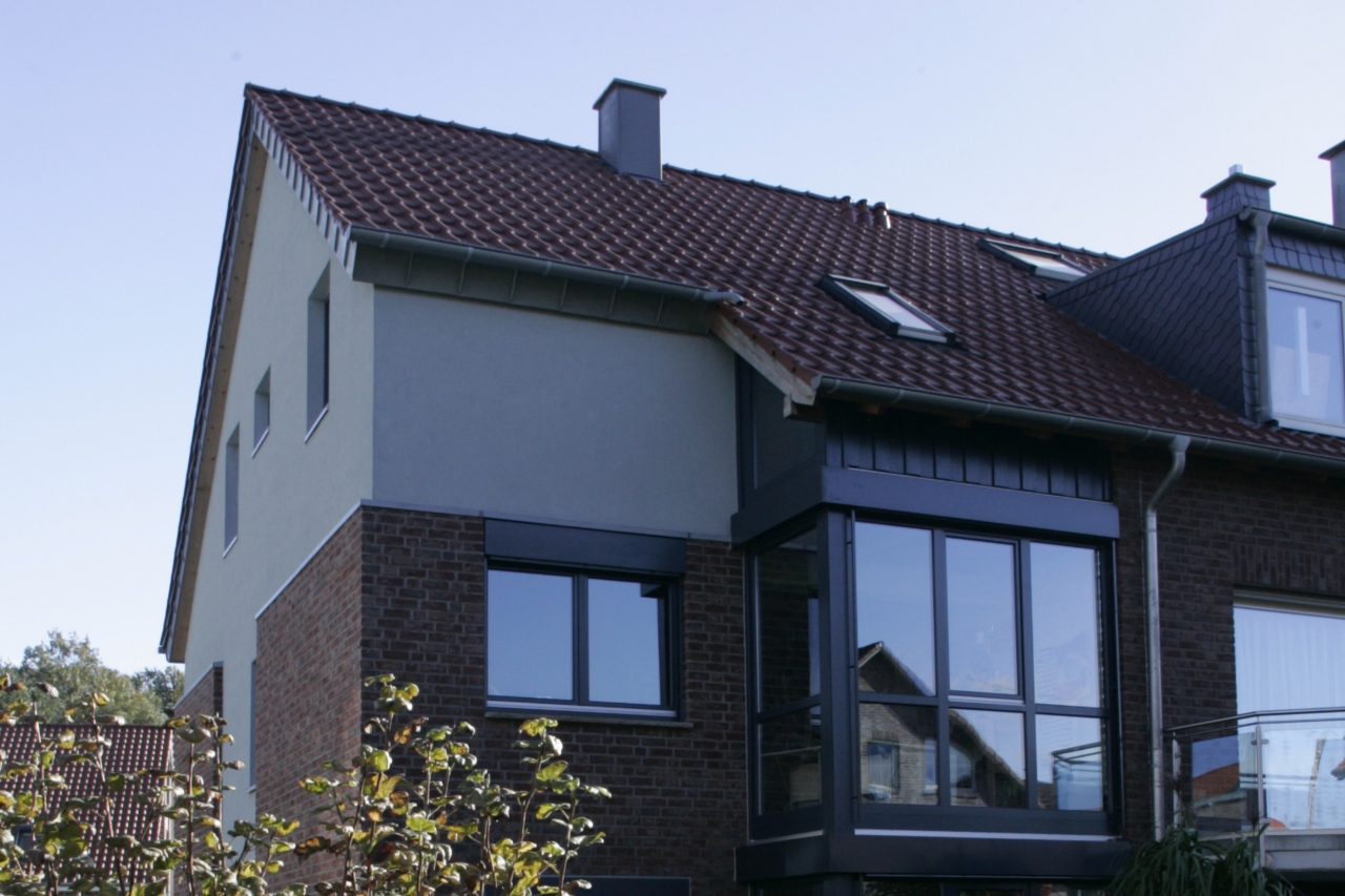 Dunkel verkleidete Erweiterung eines Wohnhauses